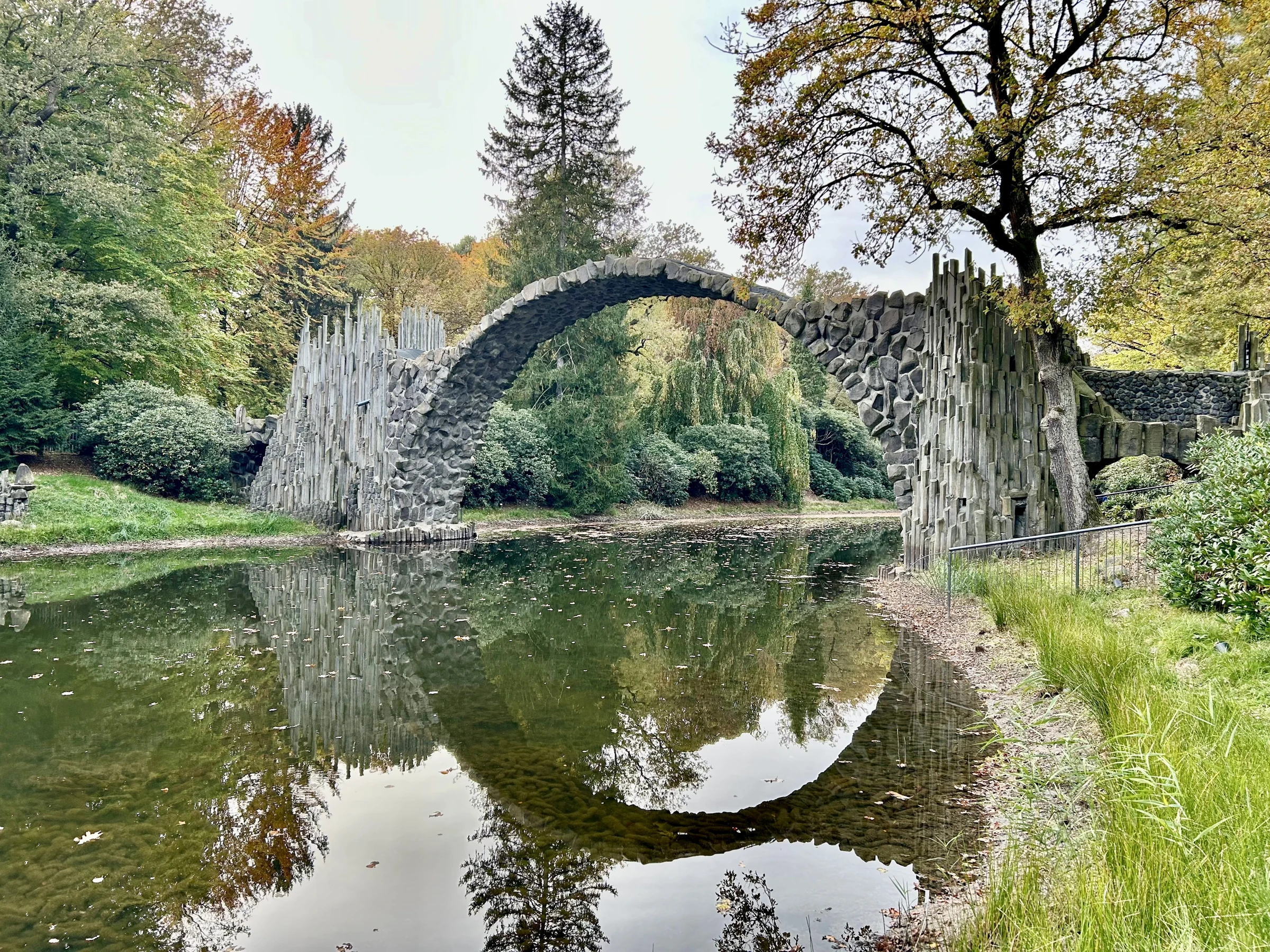 Rakotzbrücke aus seitlicher Perspektive mit Spiegelung im Kromlauer Park