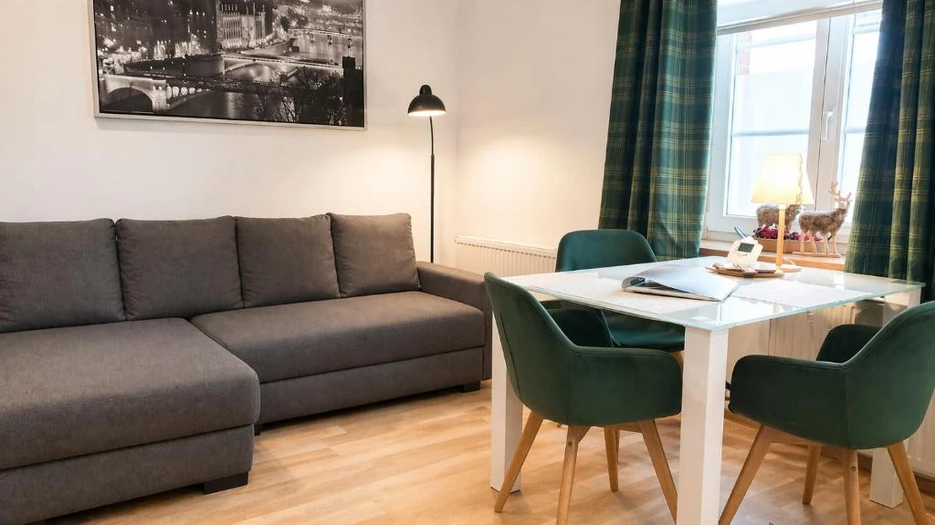 Wohnbereich mit Sofa und Esstisch · Der grüne Fürst · Ferienwohnung 1